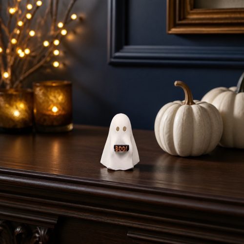 Drei weiße Geisterfiguren mit rotem Herz, BOO!-Schild und orangefarbenem Kürbis auf einem Holztisch